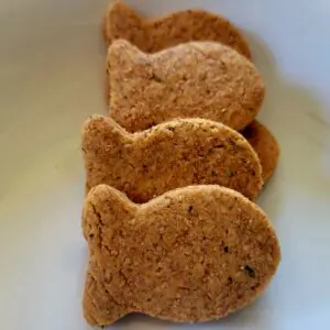 A white plate with some cookies shaped like fish