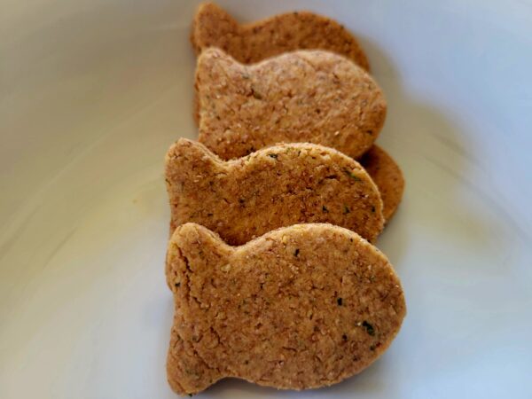 A white plate with some cookies shaped like fish