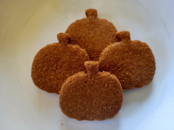 A white plate topped with four cookies covered in cinnamon.